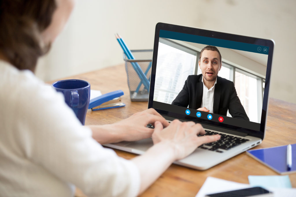 Businesswoman making video call to business partner using laptop