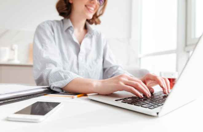Cropped photo of pretty brunette woman typing email on laptop co
