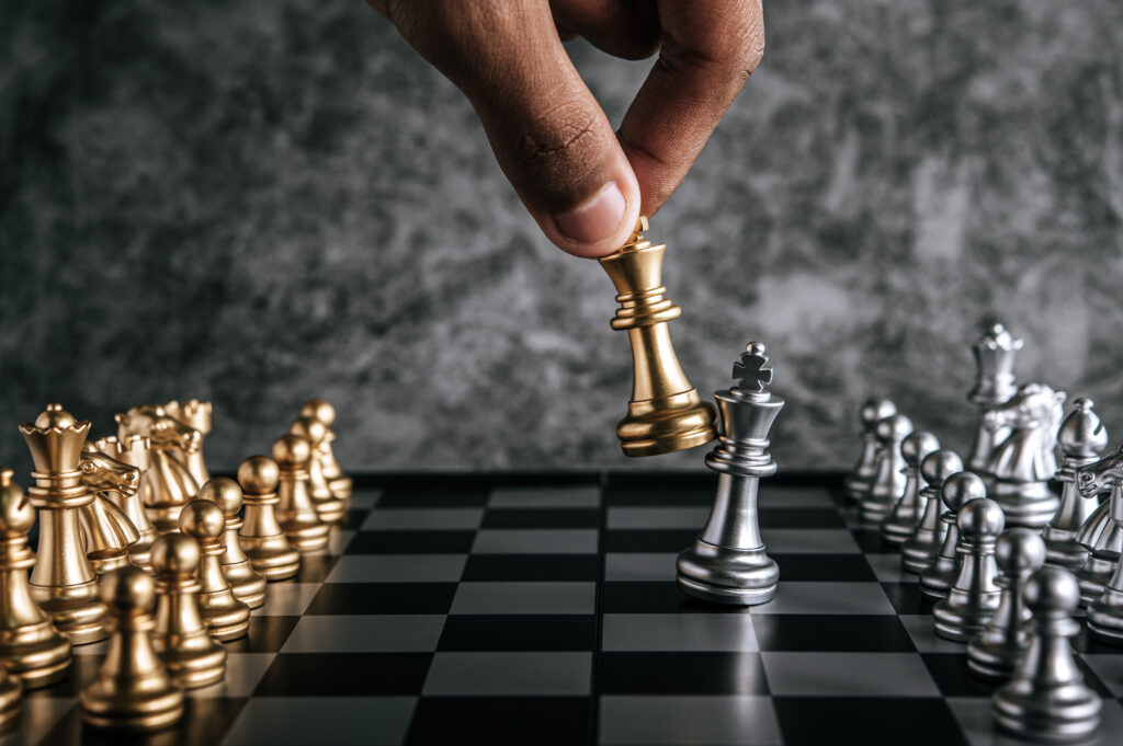 Hand of man playing chess for business planning and comparison o